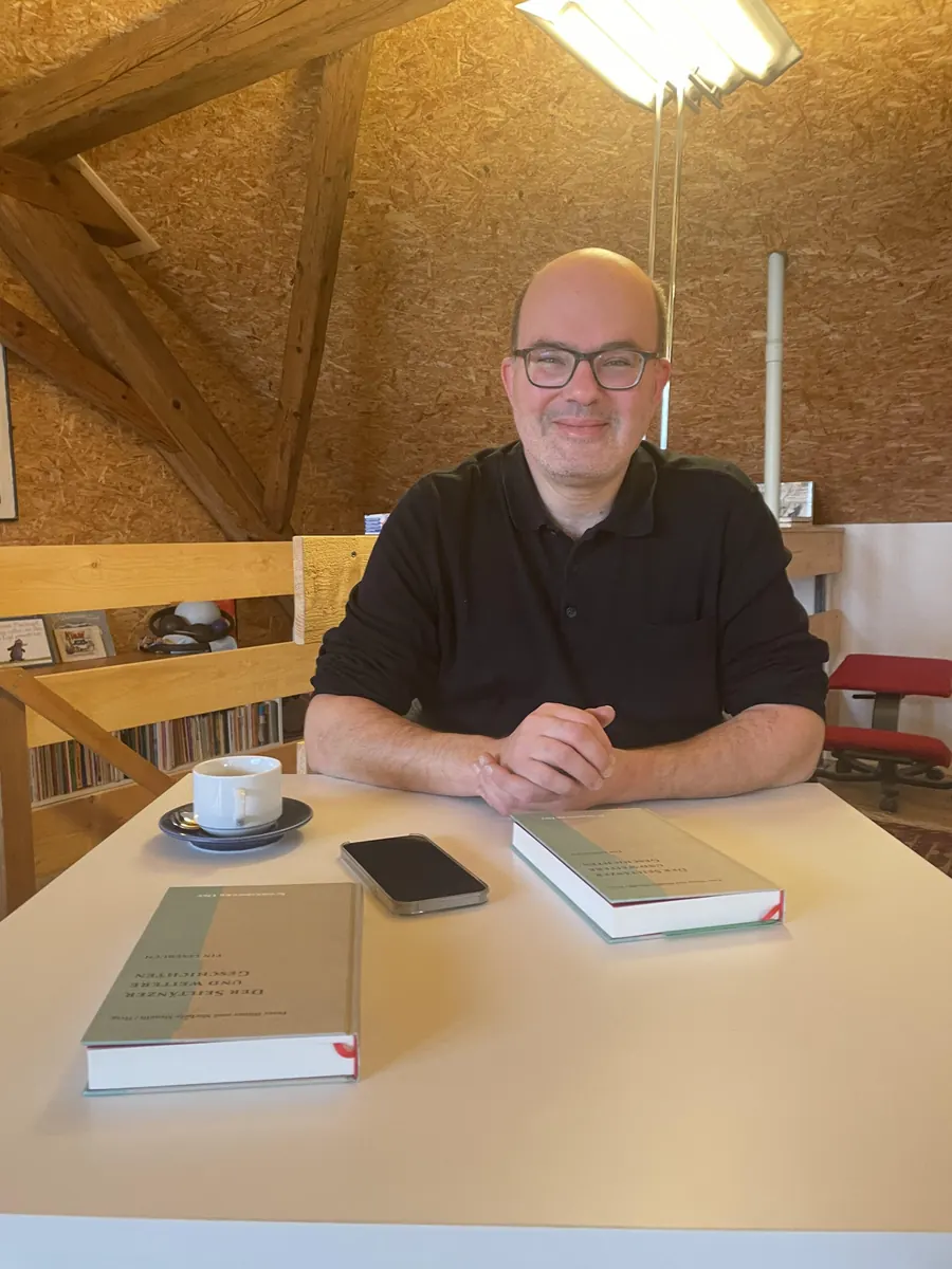 Thomas Trostmann an einem Tisch mit Büchern
